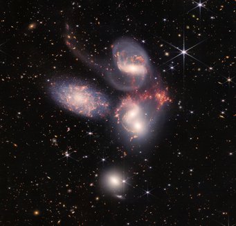 High five: "Stephan's quintet", a visual grouping of five galaxies. Five galaxies against a black background sprinkled with bright dots and objects.