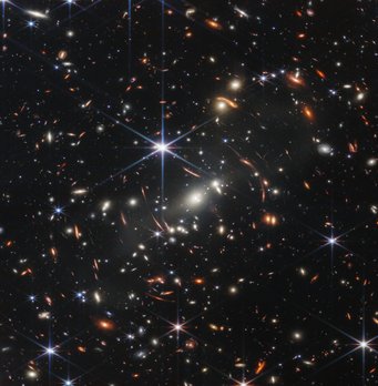 Window into the past: the light emitted by some of the galaxies in this picture has been travelling for more than 13 billion years. Numerous coloured dots and elongated oval objects against a black background.